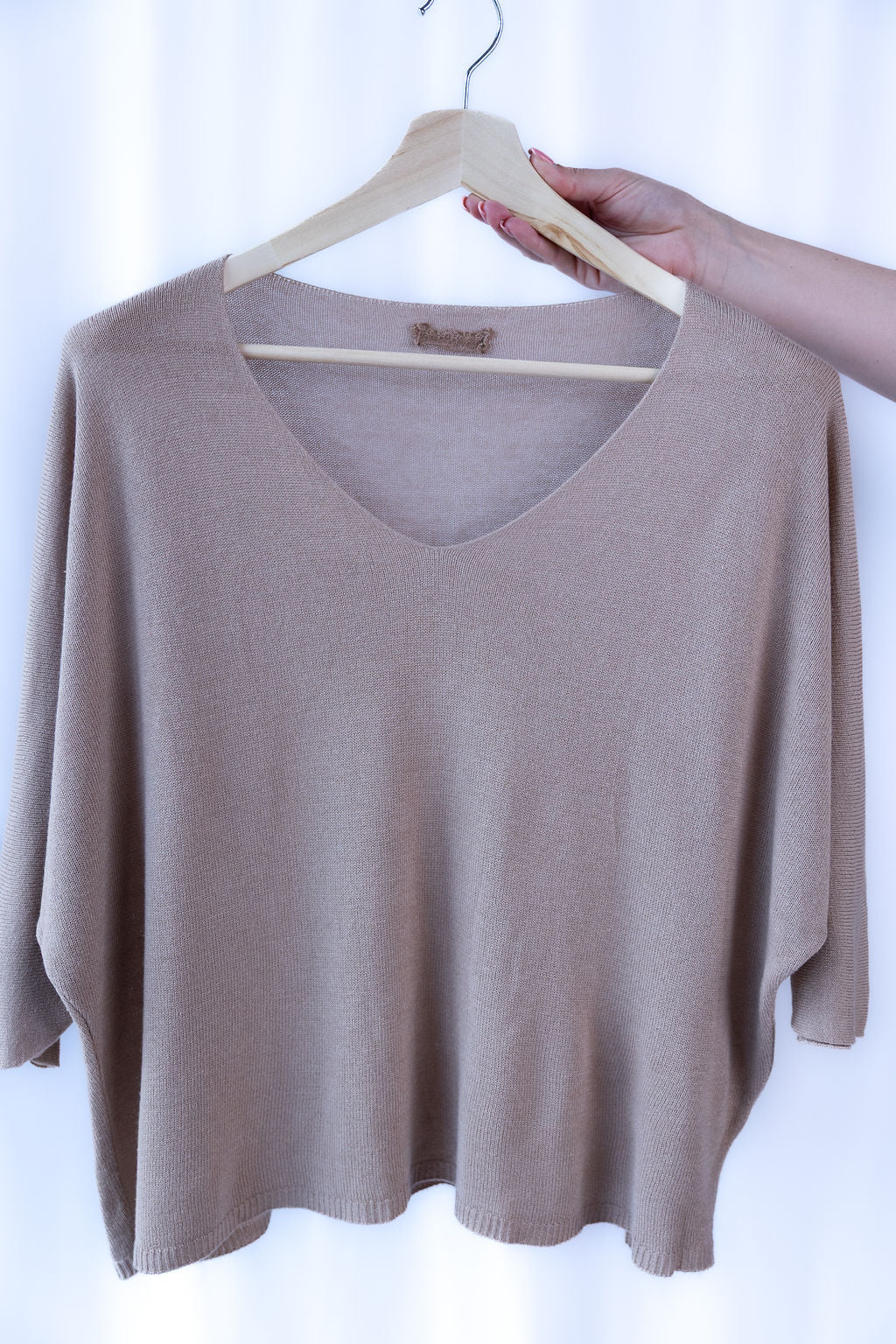 Beiger Strickpullover mit weitem Schnitt auf Holzkleiderbügel