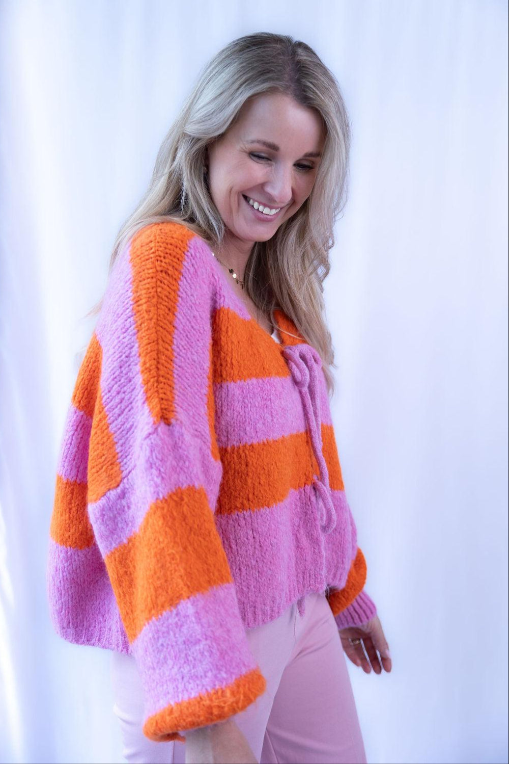 Frau im orange-pinken Strickpullover mit weitem Schnitt