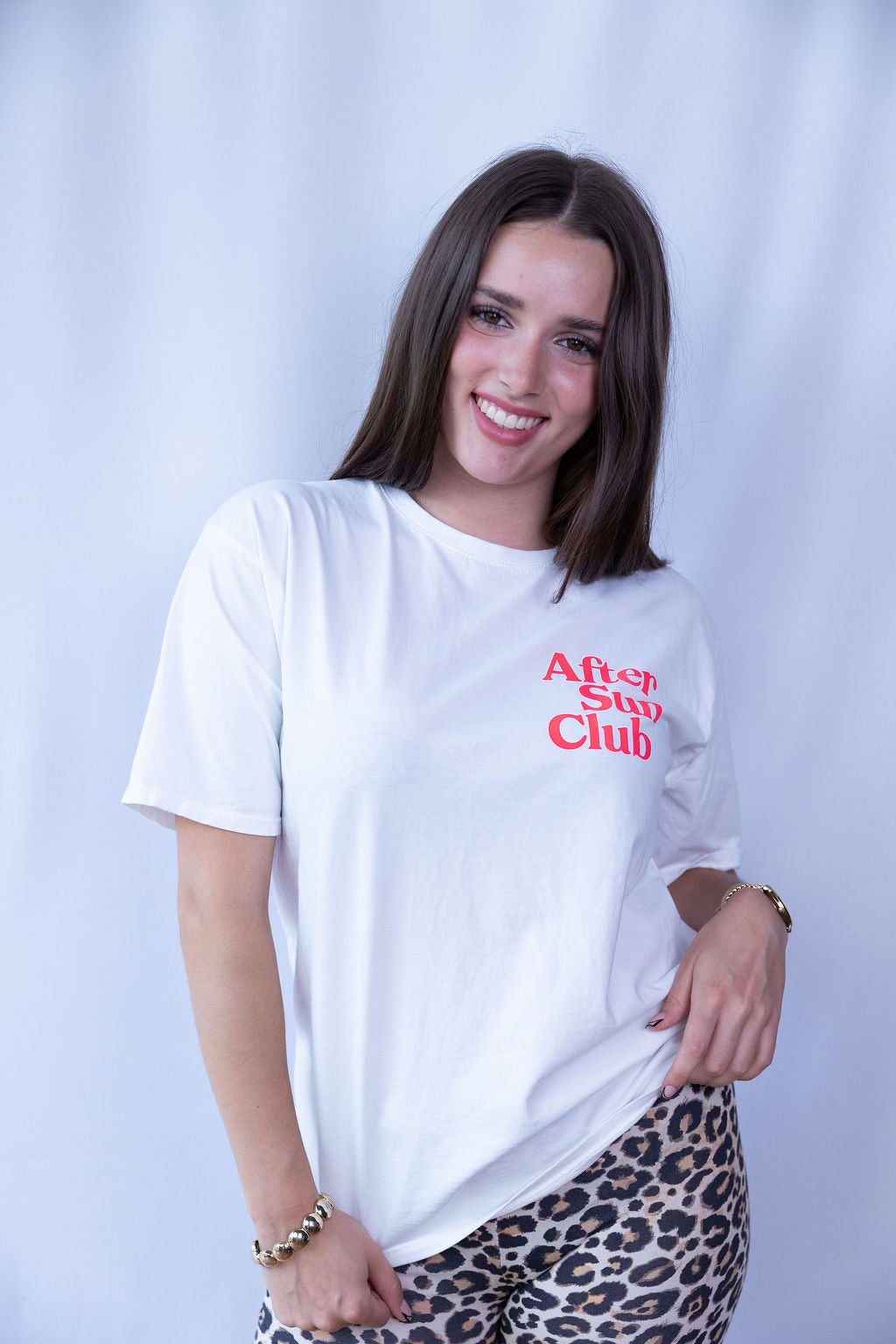 Weißes Damen-T-Shirt mit kleinem roten „After Sun Club“-Print vorne, locker getragen