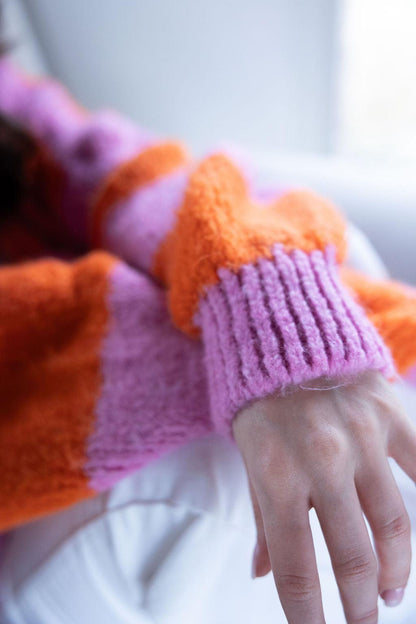 Detailaufnahme orange-pinker Strickpullover-Ärmel