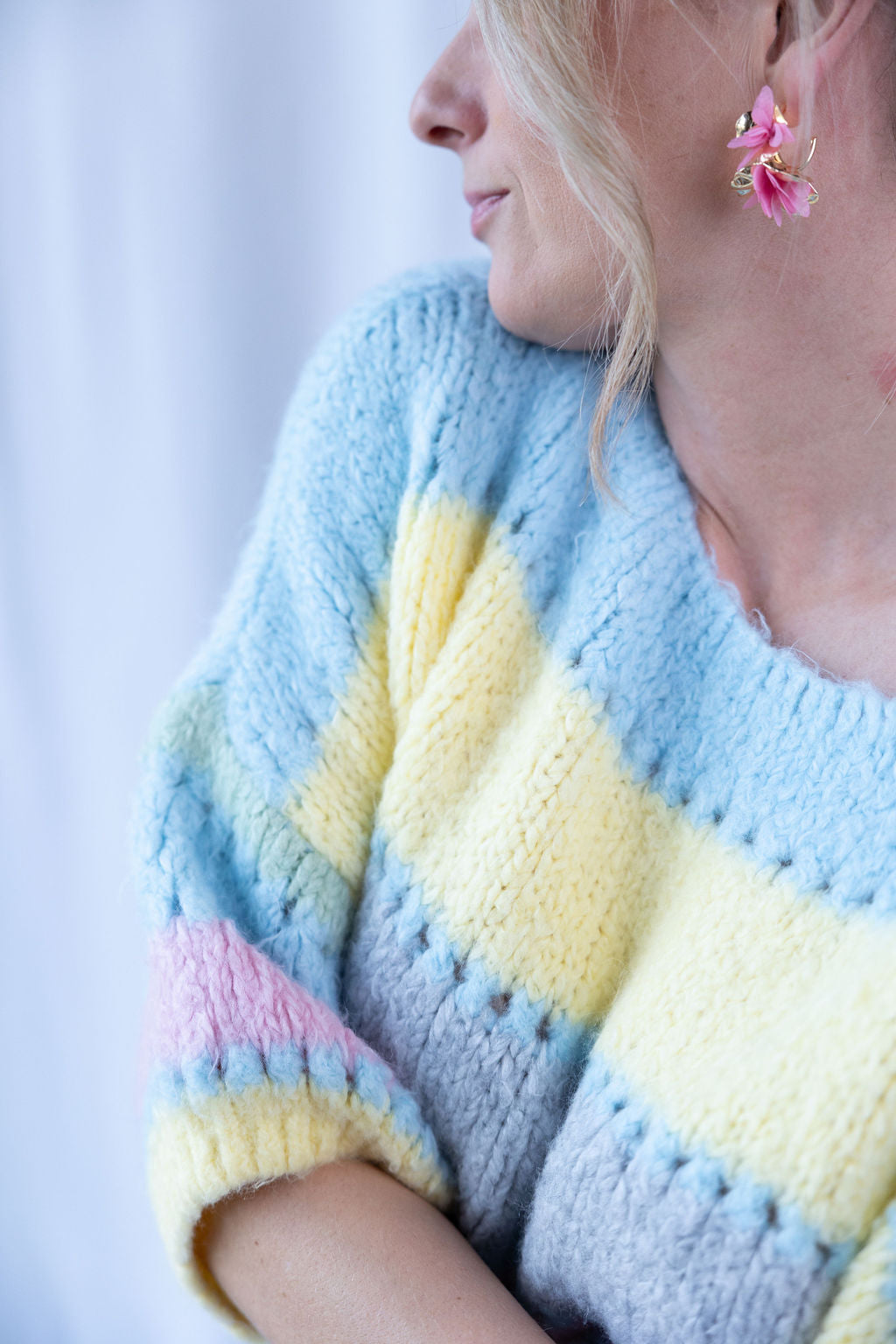 Pastellfarbener Strickpullover mit rosa, gelb und blauem Streifenmuster