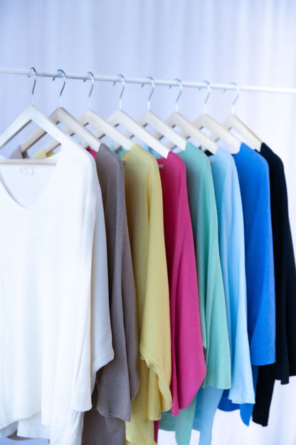 Sortierte Pullover in Pastell- und Naturtönen auf Bügeln